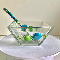 Glass dip bowl with leaning spoon